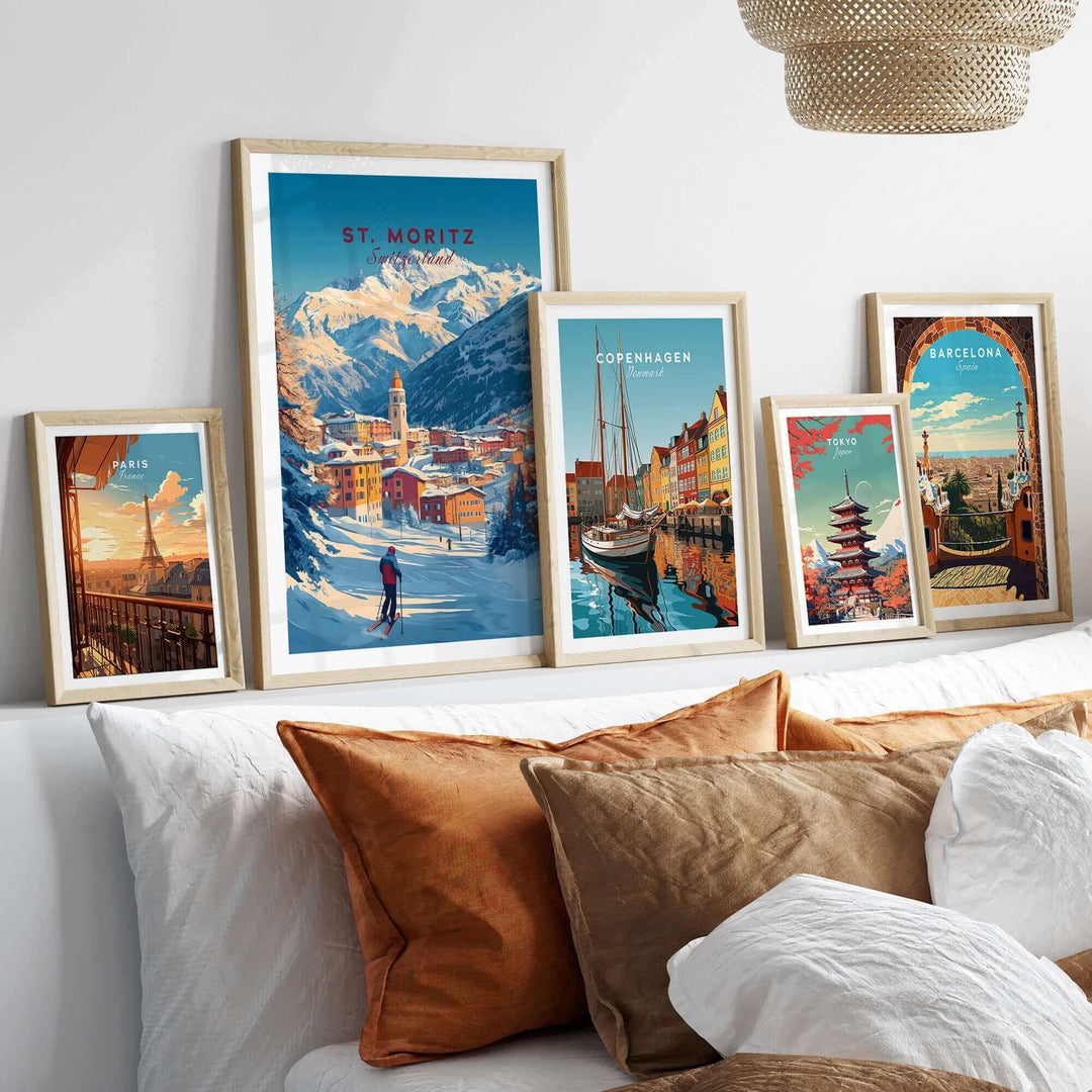 St Moritz ski poster and other travel art prints displayed on a shelf above a couch with pillows.