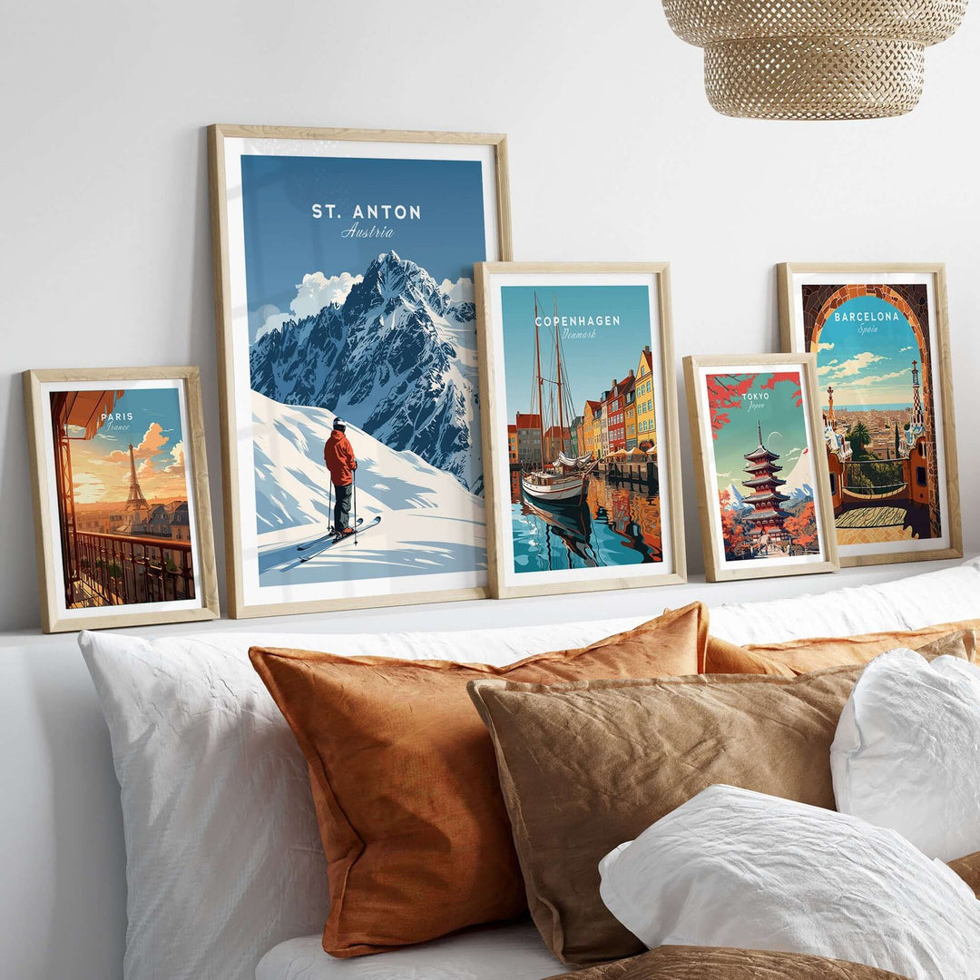 St. Anton ski print displayed among framed travel art on a cozy bed, highlighting winter adventure decor.