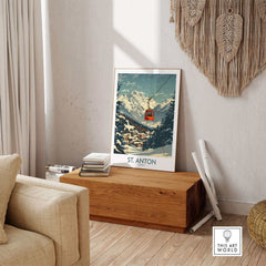 St. Anton wall art ski poster featuring a snowy mountain scene with a red gondola, set in a cozy living room with rustic decor.