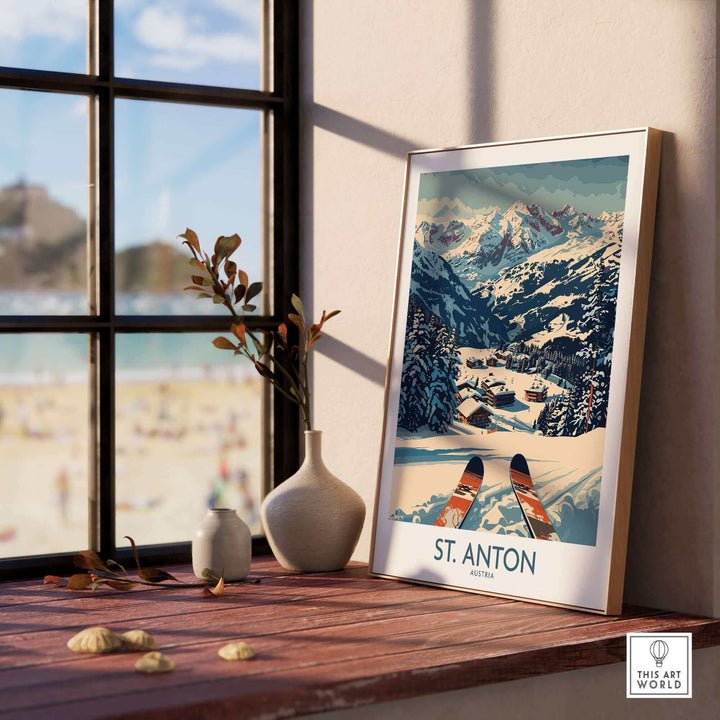 Vintage St. Anton wall art ski poster displayed on a wooden table by the window with alpine view in background.