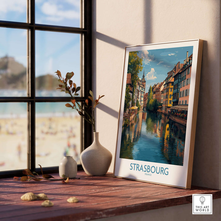 Strasbourg France Art Print | Petite France Travel Poster displayed beside a window showcasing vibrant canal views.