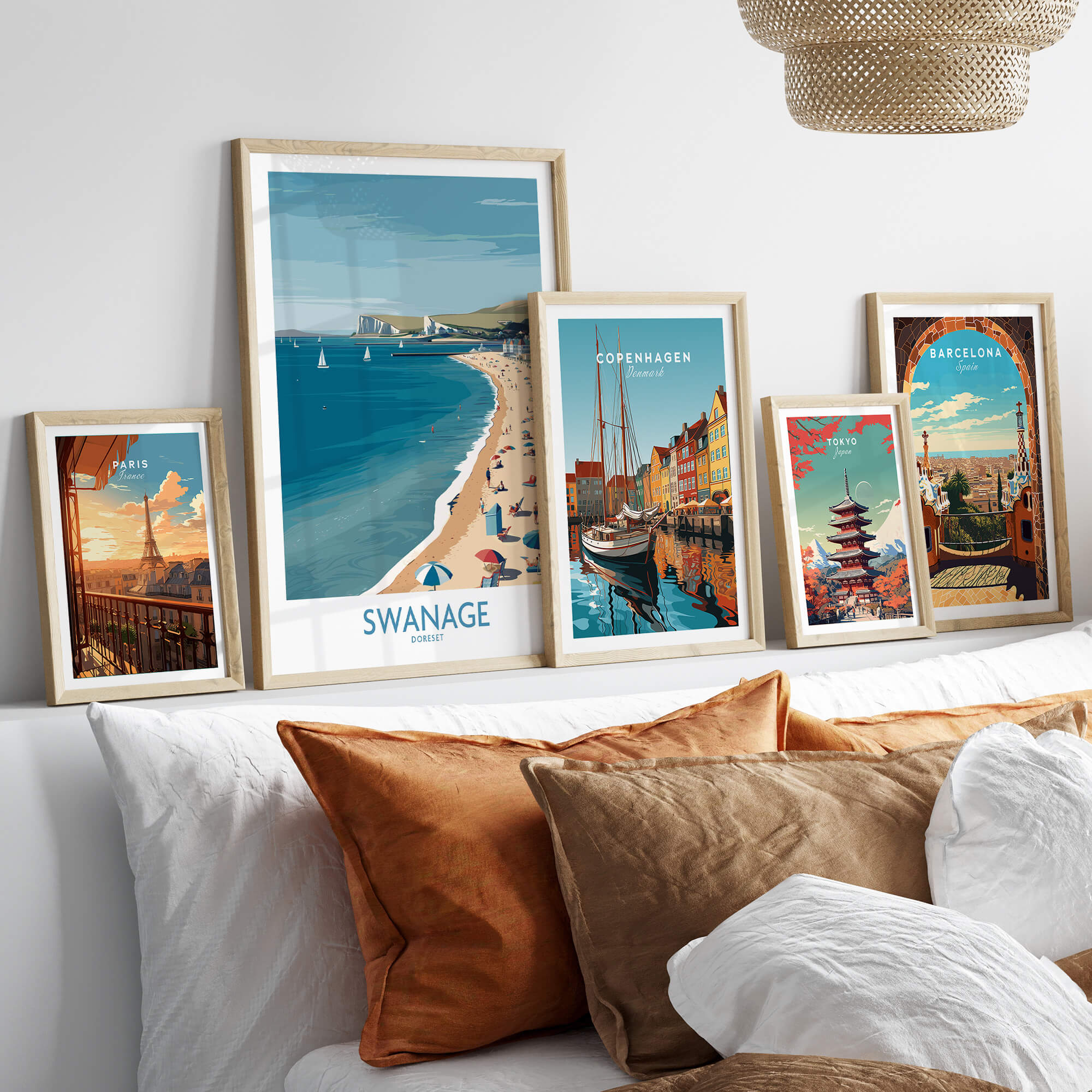 Swanage Dorset Poster | White Cliffs & Coastal Sailboat Scene Canvas Print displayed among other travel posters on a stylish couch.