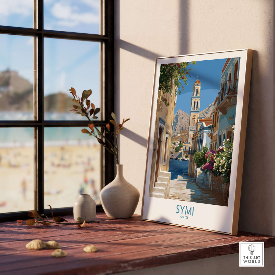Symi Greece Art Print Greek Poster displayed on wooden desk near window with beach view.