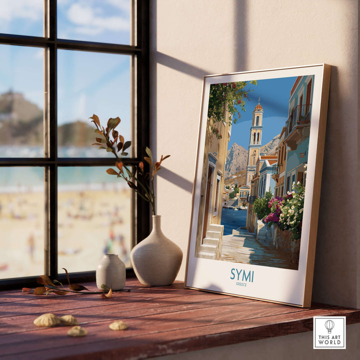 Symi Greece Art Print Greek Poster displayed on wooden desk near window with beach view.