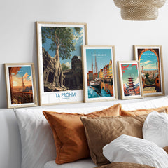 Ta Prohm Cambodia Poster | Sunset Jungle Temple Scene Canvas Print displayed among framed travel posters on a cozy sofa.