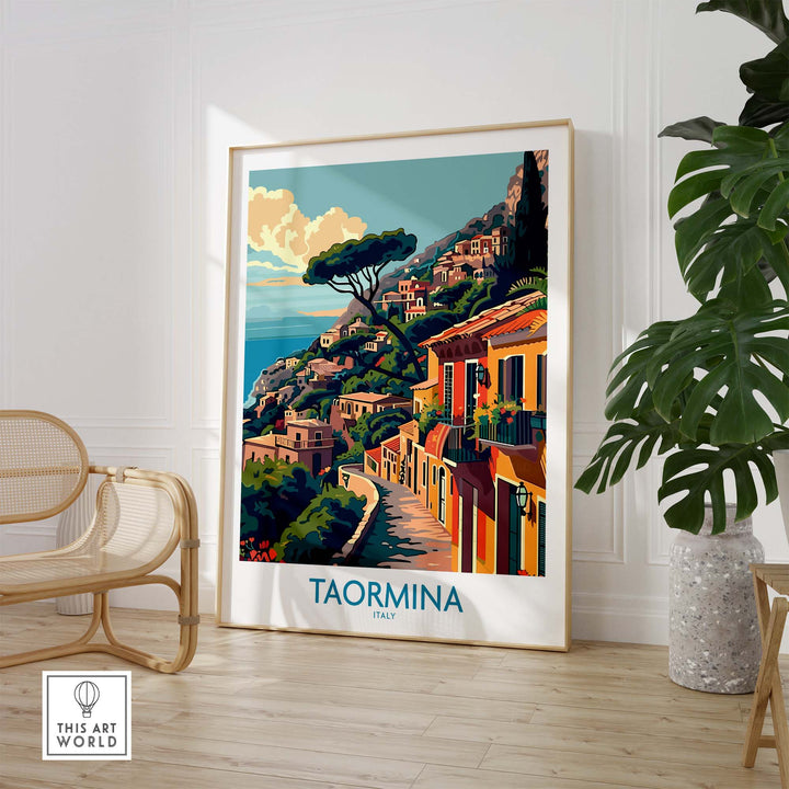 Taormina Travel Print - Vibrant Souvenir of Italy's Beautiful Coastline displayed in a stylish room with wicker chair and plant.