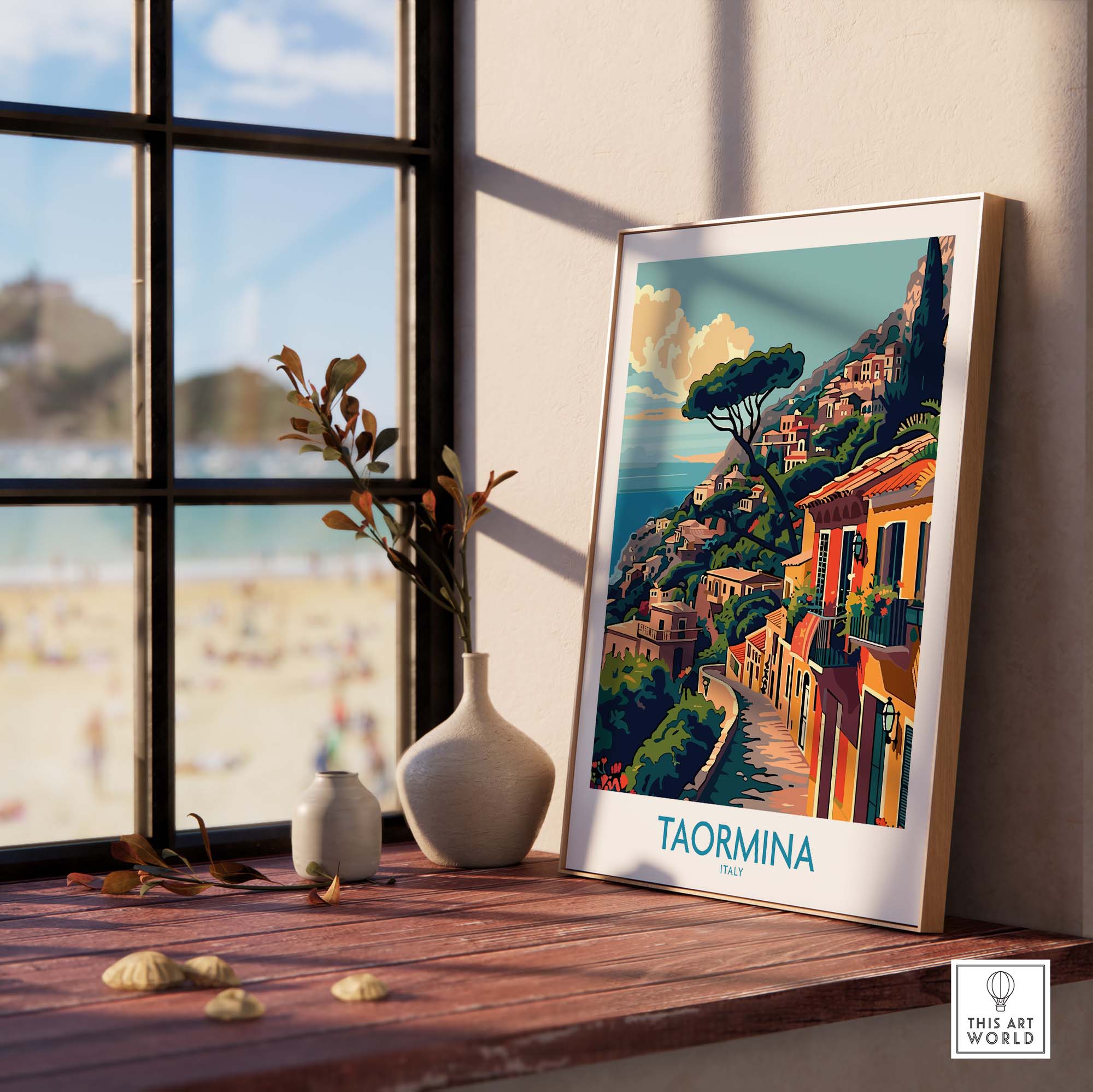 Taormina Travel Print - Vibrant Souvenir of Italys Beautiful Coastline displayed on a wooden table near a window.