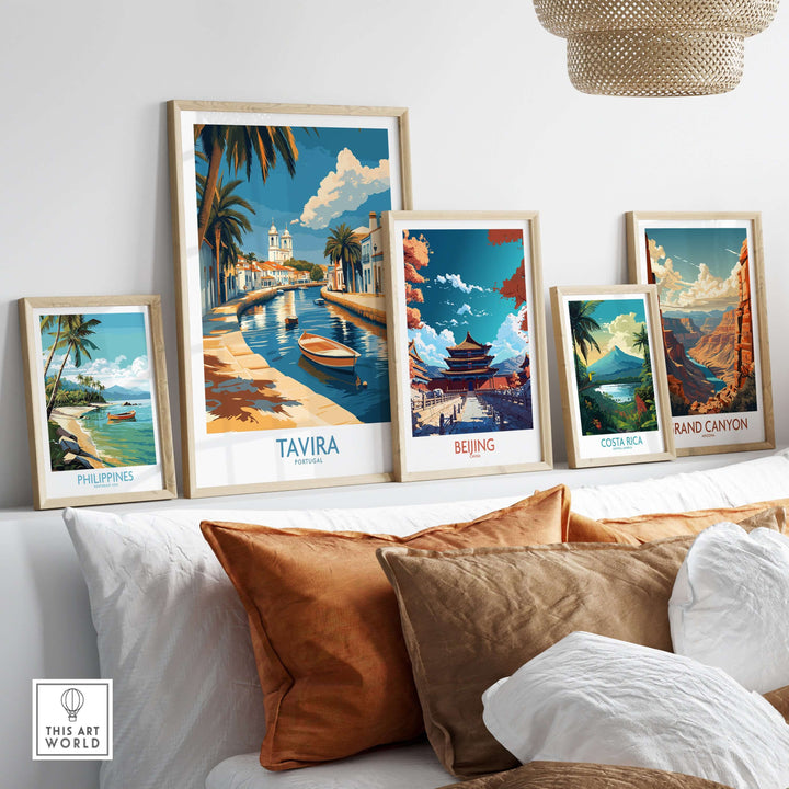 Collection of framed travel posters including Tavira, Portugal, on a stylish wall with a cozy sofa.