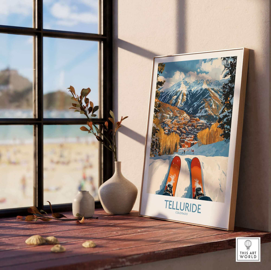 Telluride ski poster wall art featuring snowy mountains and skis displayed on a windowsill.