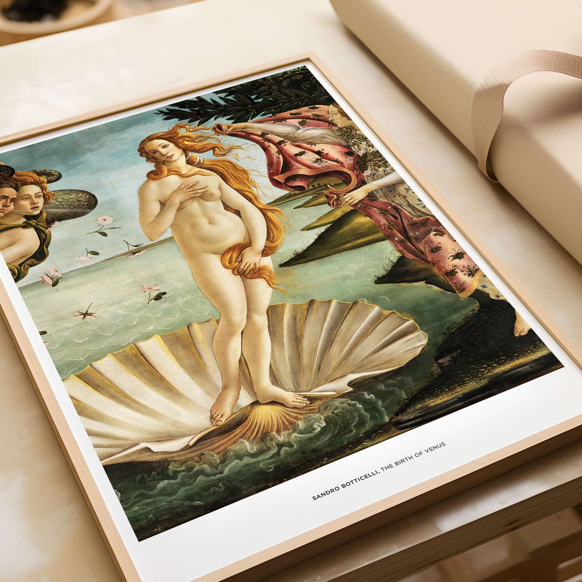 The Birth of Venus Art Print Sandro Botticelli Mythology Poster displayed elegantly on a table.