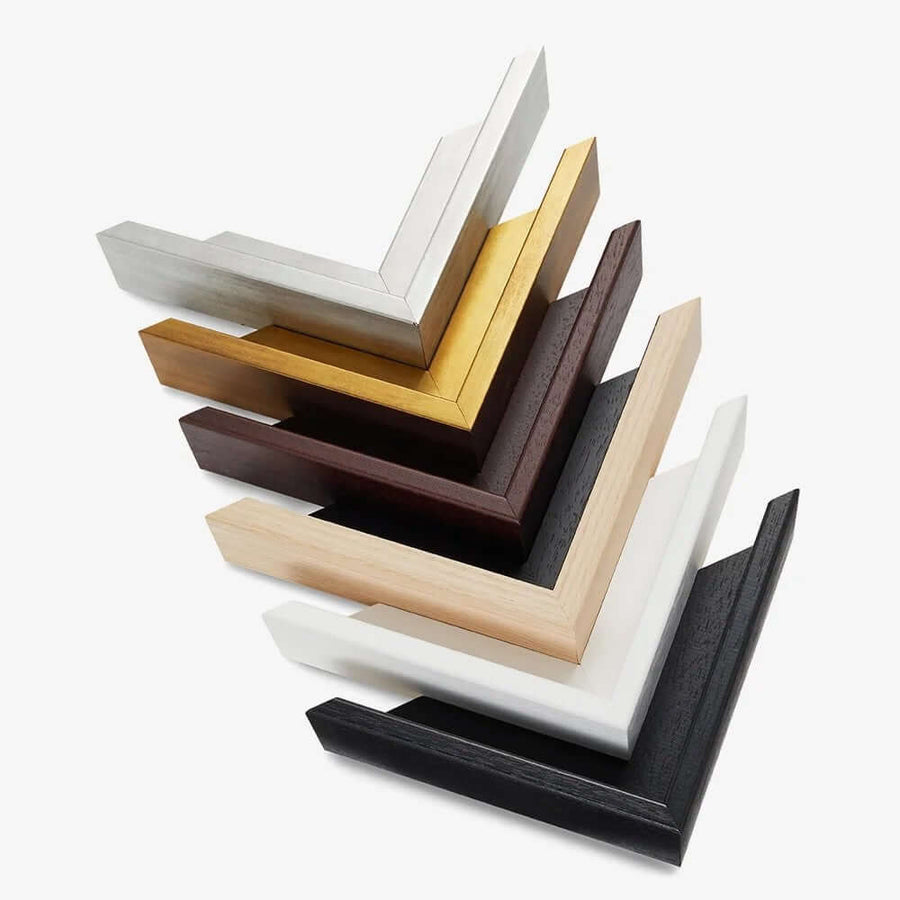 Stack of canvas frame corner samples in silver, gold, brown, black, white, and wood finishes