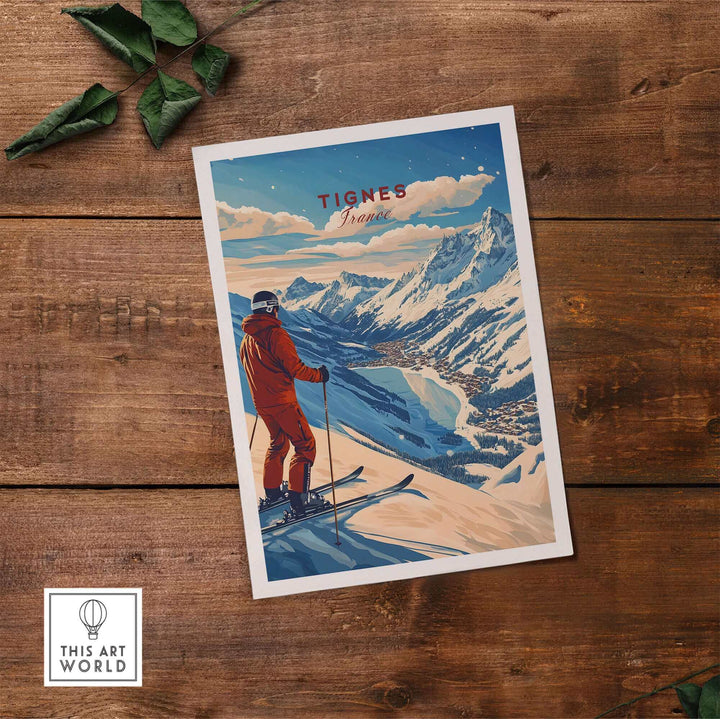 Tignes Print France Ski Poster displayed on wooden surface with mountain scene and skier in red outfit.