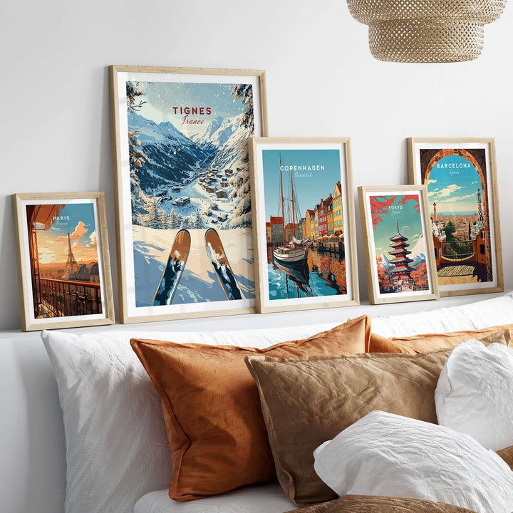 Collection of travel posters featuring Tignes, Copenhagen, and Barcelona displayed on a stylish wall above a cozy sofa.