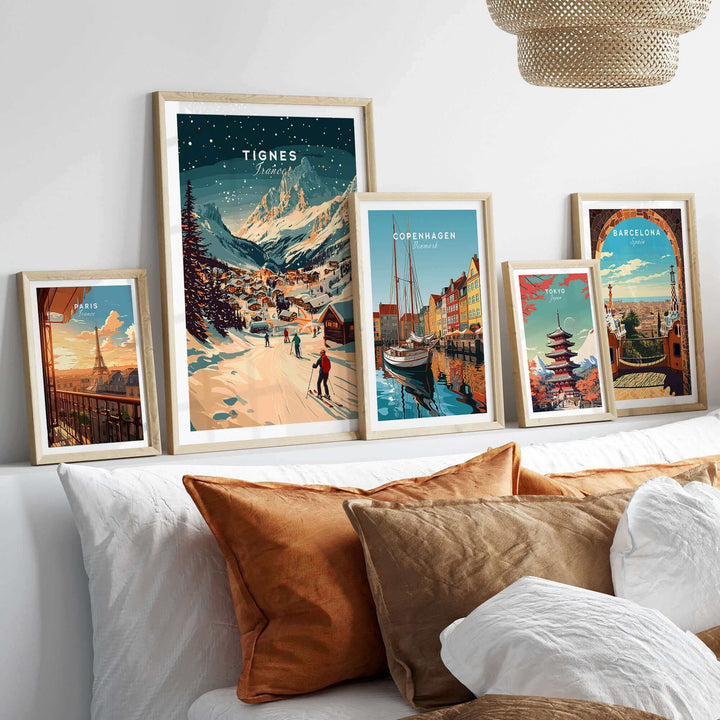 Collection of framed ski and travel-themed wall art including Tignes print, displayed on a shelf above a bed.