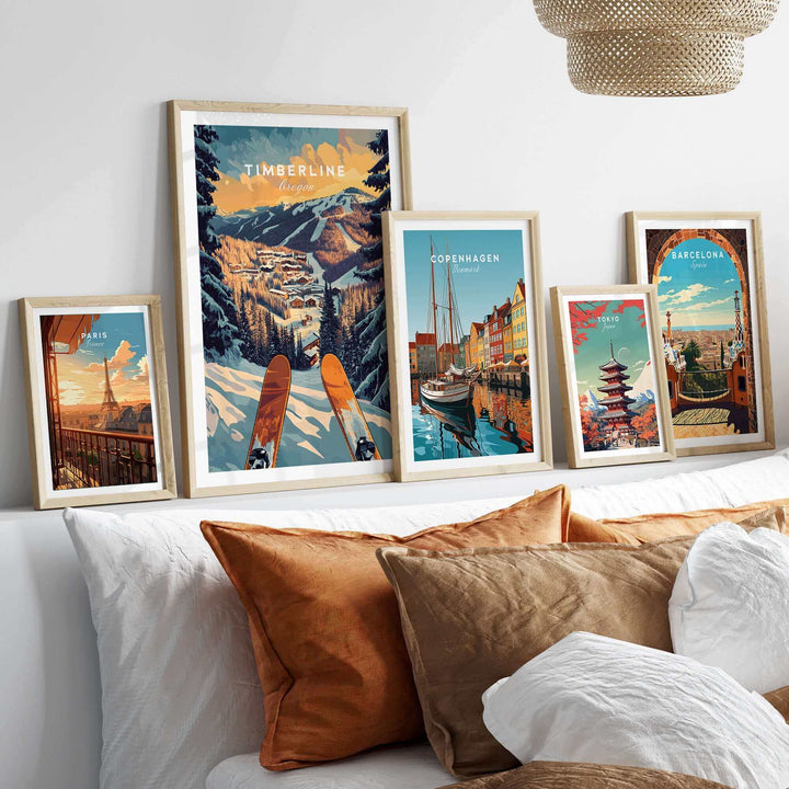 Collection of framed travel posters featuring Timberline ski landscape, Copenhagen harbor, and Barcelona architecture above a sofa.