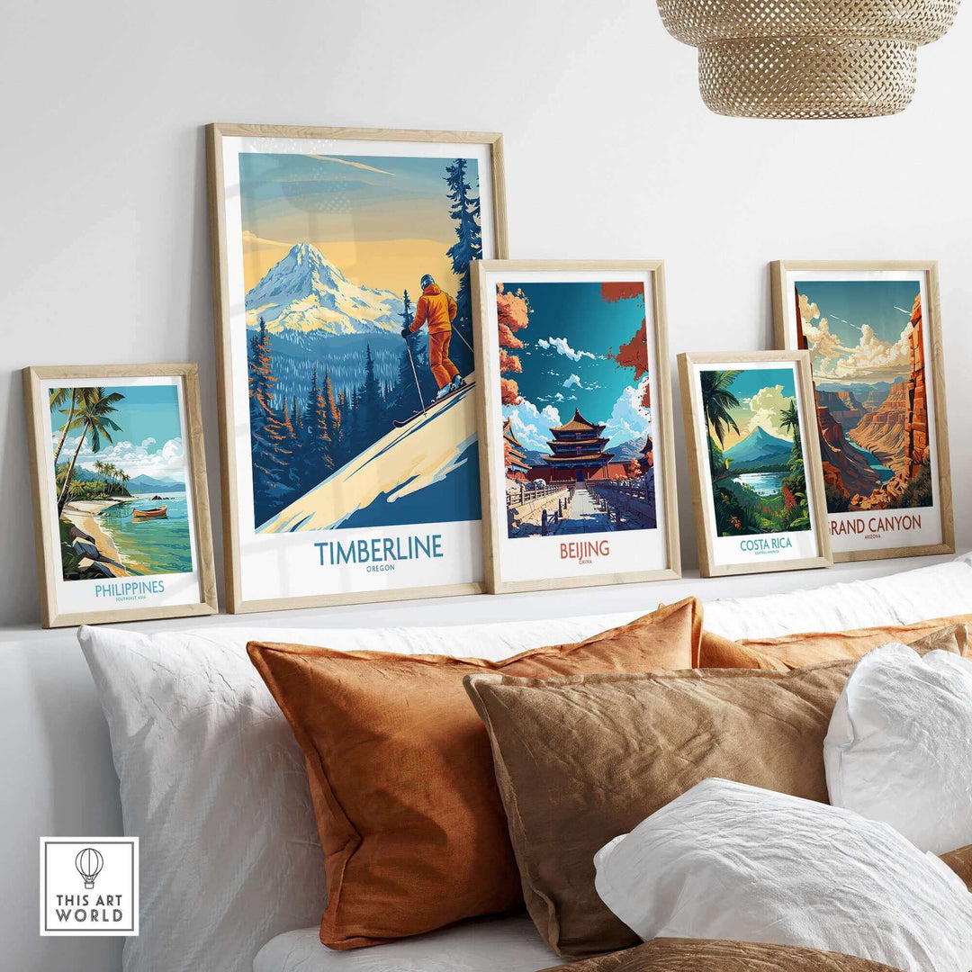 Collection of scenic travel posters including Timberline ski art, displayed on a shelf with pillows underneath.