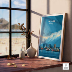 Tromsø Wall Art Print | Norwegian City Wall Decor displayed on a wooden table near a window with beach view.