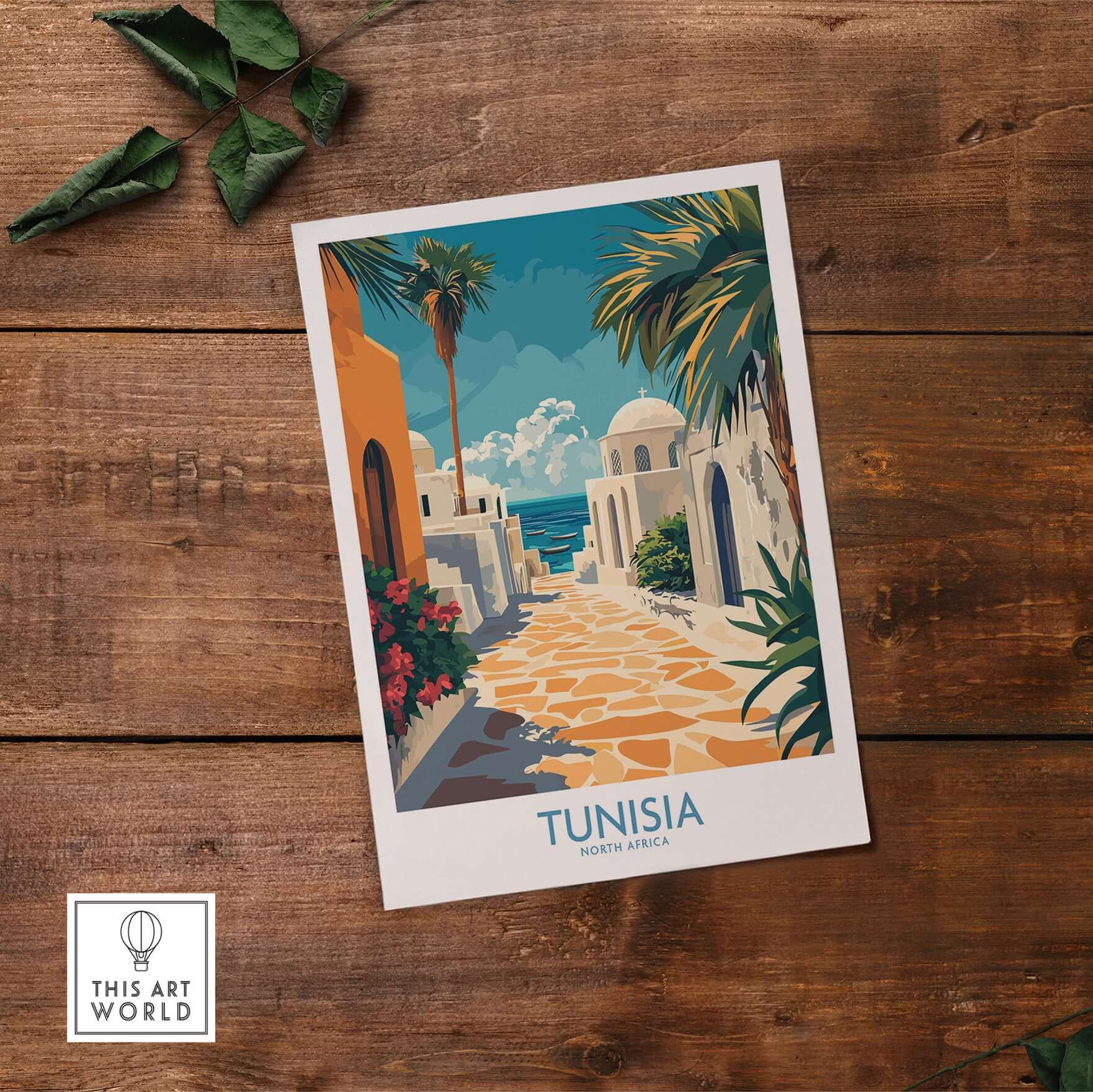 Tunisia Poster - North Africa Travel Print - Blue and White Wall Decor displayed on wooden surface with plants.