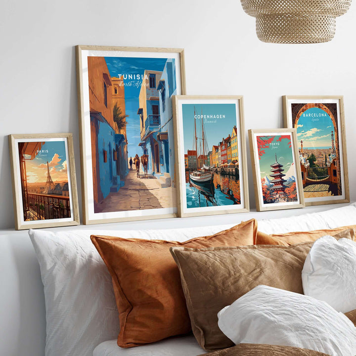 Collection of travel prints including Tunisia, Copenhagen, and Barcelona displayed on a decorative wall.
