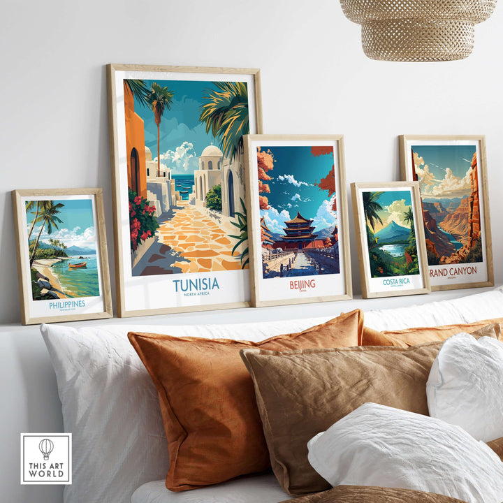 Framed travel posters including Tunisia, Beijing, and Costa Rica displayed on a wall with decorative pillows.