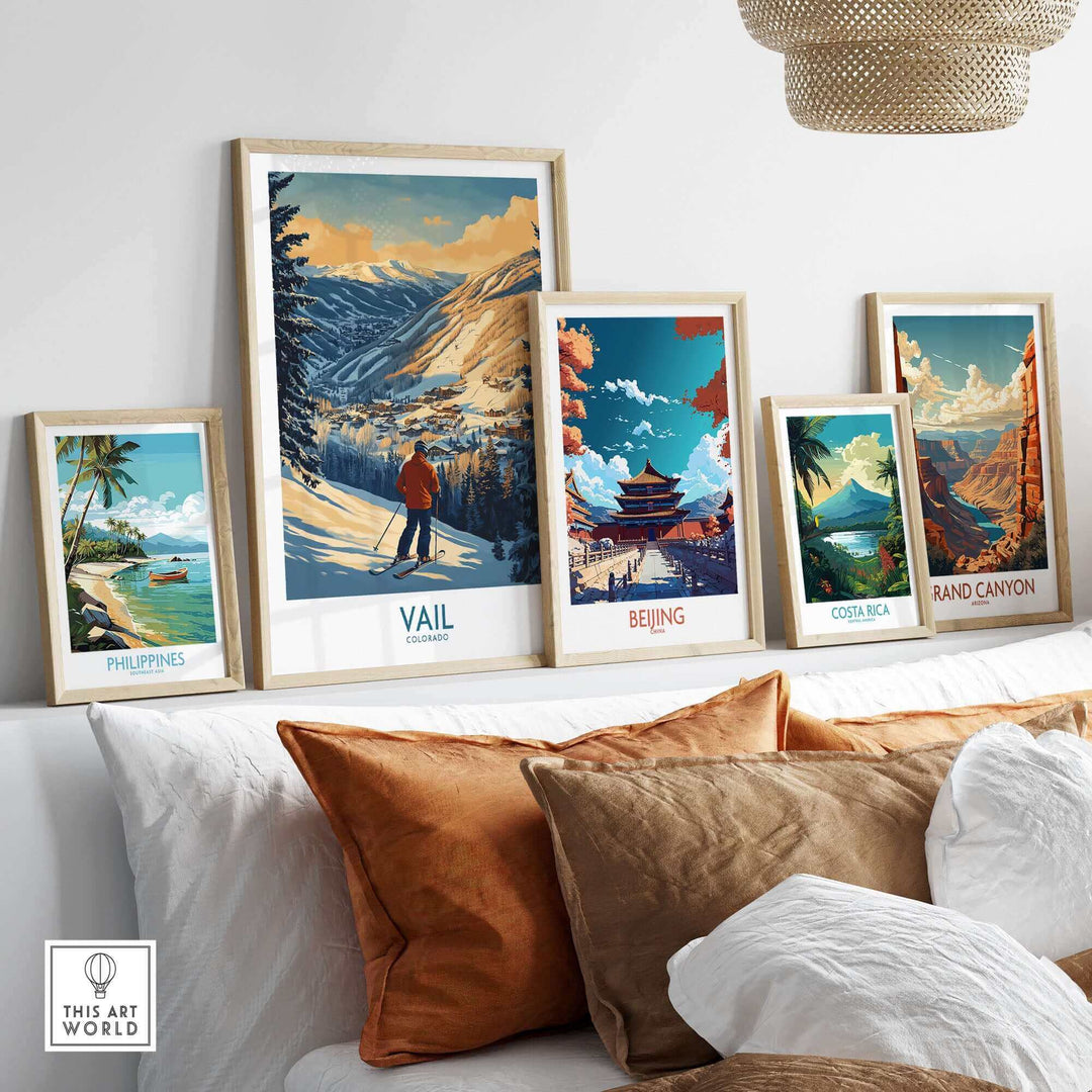 Collection of framed travel posters featuring Vail Colorado, Philippines, Beijing, Costa Rica, and Grand Canyon prints on a couch.