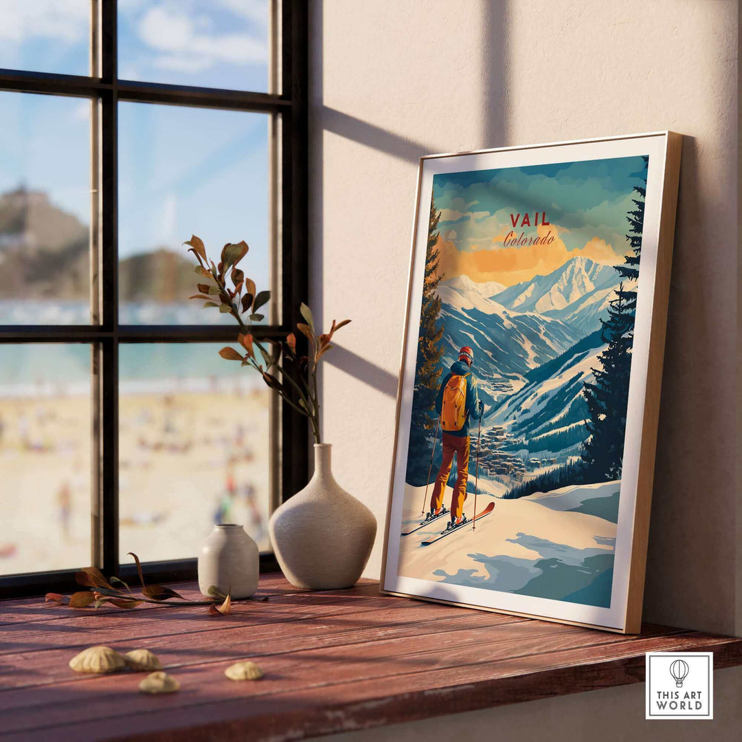 Framed Vail Ski Poster featuring Colorado mountains, displayed on a wooden table near a window with decorative vases.