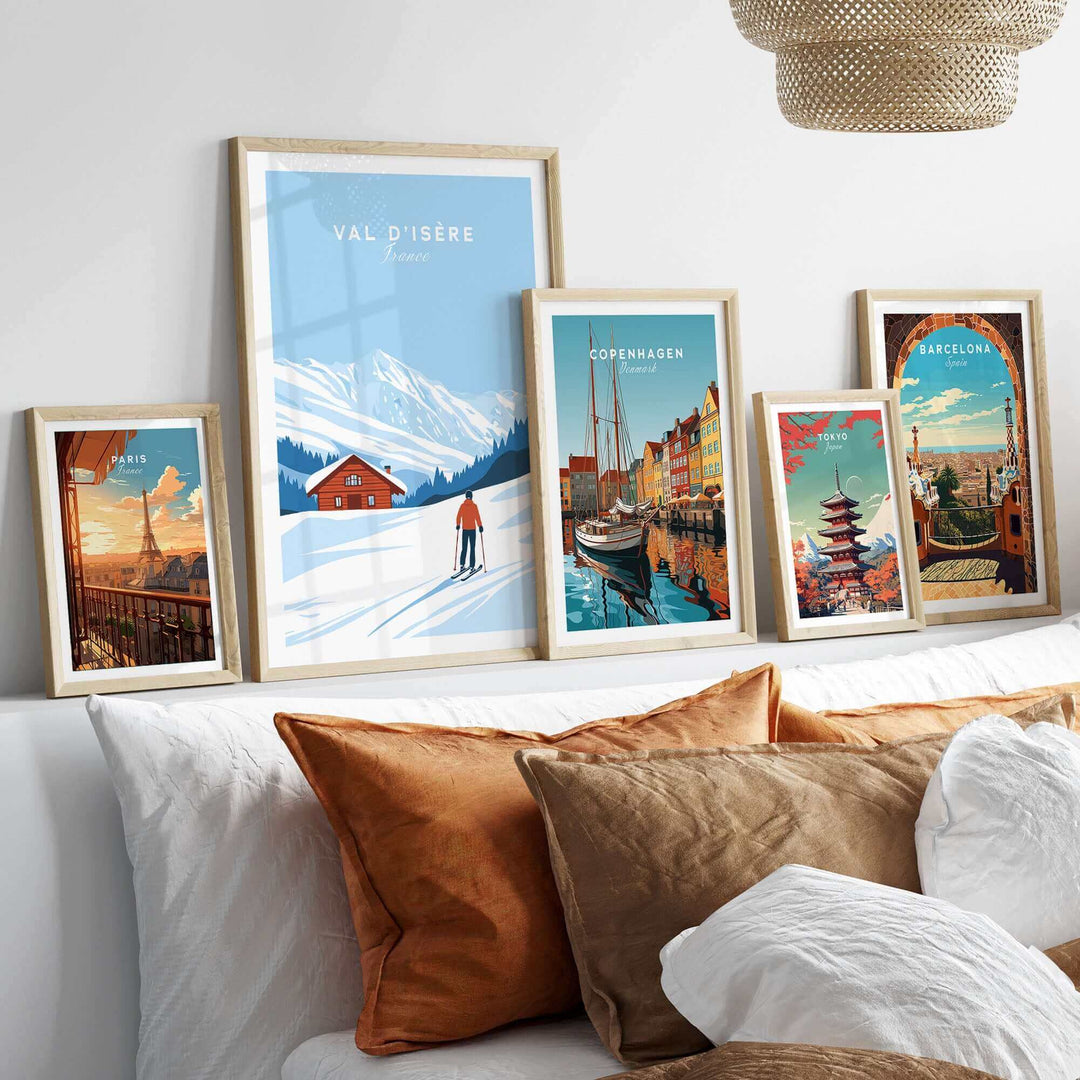 Val-d'Isère France ski poster in framed display with scenic travel art of Copenhagen, Barcelona, and more on cozy couch setting.