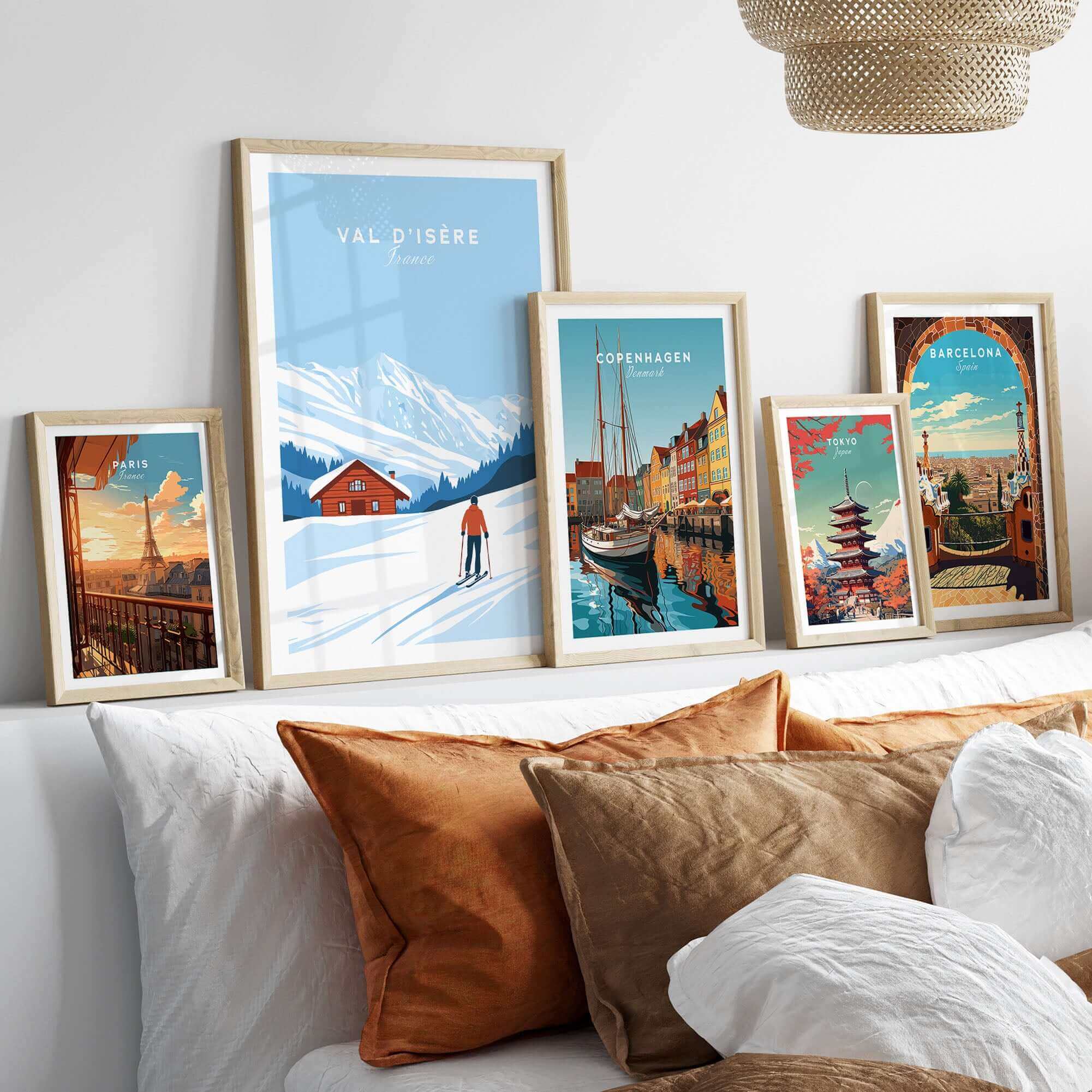 Val-d'Isère France ski poster in framed display with scenic travel art of Copenhagen, Barcelona, and more on cozy couch setting.
