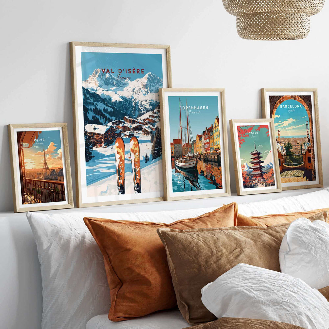 Collection of framed travel prints, including Val-d'Isère ski scene, showcased on a sofa with decorative cushions.