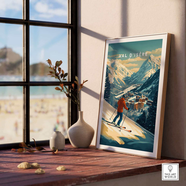 Val-d'Isère ski print wall art displayed on wooden tabletop by window with mountains in the background.