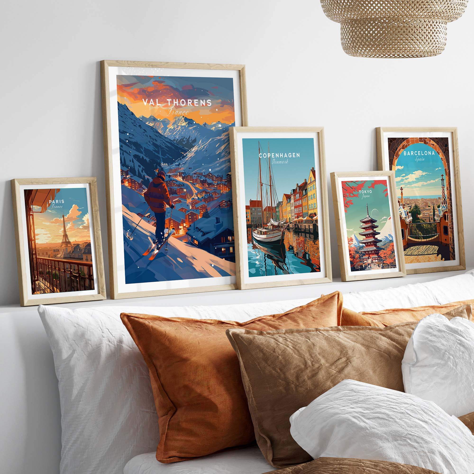 Val Thorens ski poster among framed travel prints on a cozy sofa, showcasing stunning mountain scenery and vibrant colors.