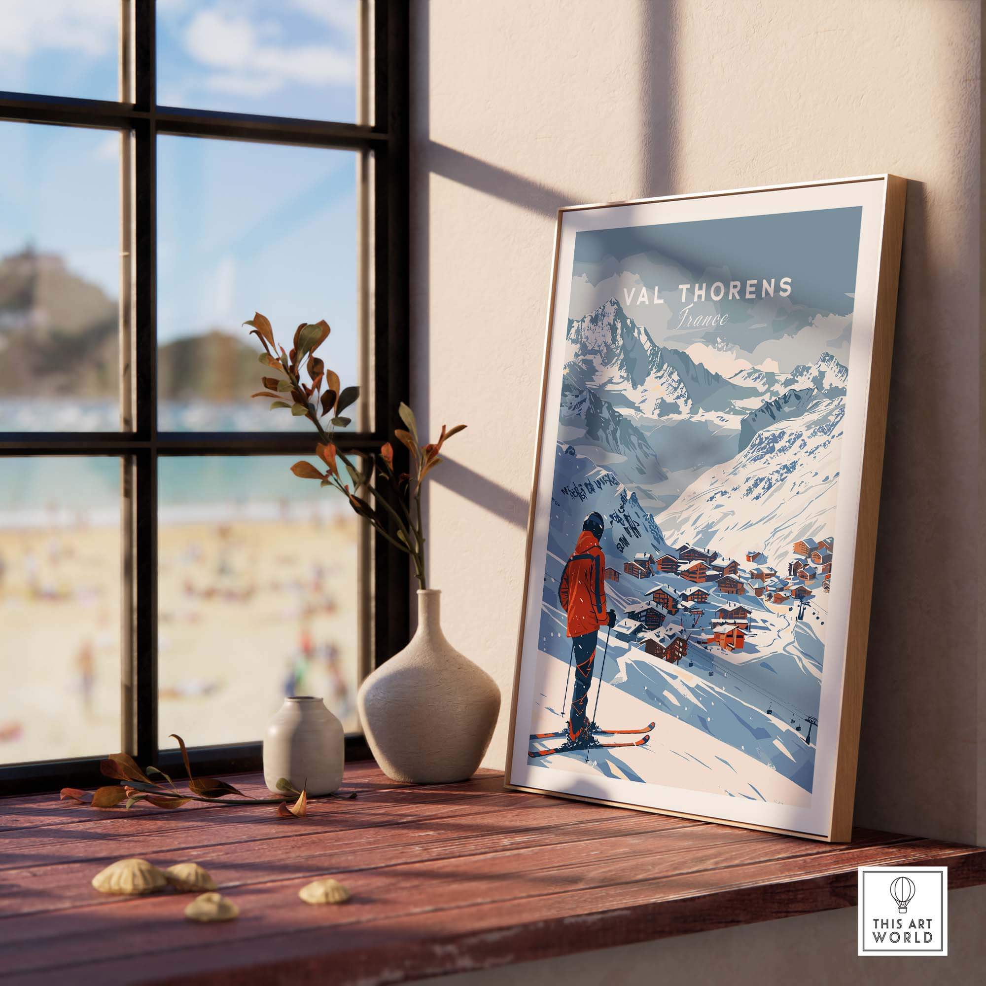 Val Thorens wall art print on a wooden table near a window, showcasing a ski scene and picturesque mountains.