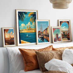 Valletta Art Print showcased among other travel prints in a cozy home decor setting on a bed with decorative pillows.