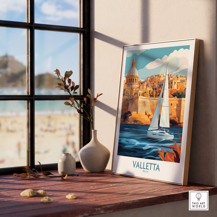 Valletta Malta poster on a table by a sunny window, featuring a sailboat and historic cityscape, perfect wall art for travel enthusiasts.