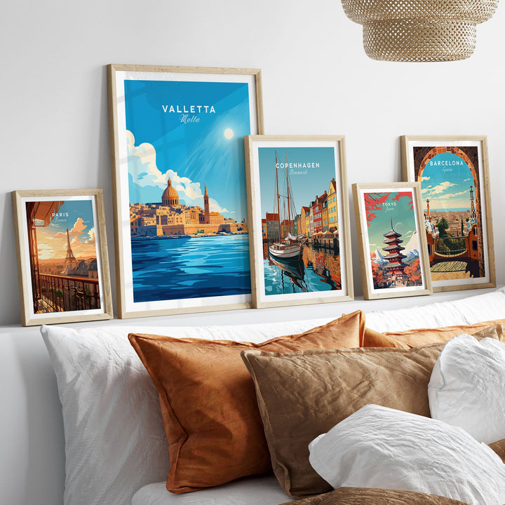 Posters of cities including Valletta, Copenhagen, and Barcelona displayed above a cozy sofa with pillows.