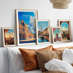 A stylish display of framed art prints, including Versailles Print France, on a modern wall above a cozy bed.