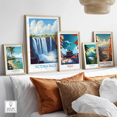 Victoria Falls Zambia Print displayed prominently among framed travel posters on a stylish shelf.