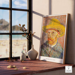 Vincent van Gogh Self Portrait Straw Hat Post-Impressionist Art Print Poster displayed on a wooden table near a window.