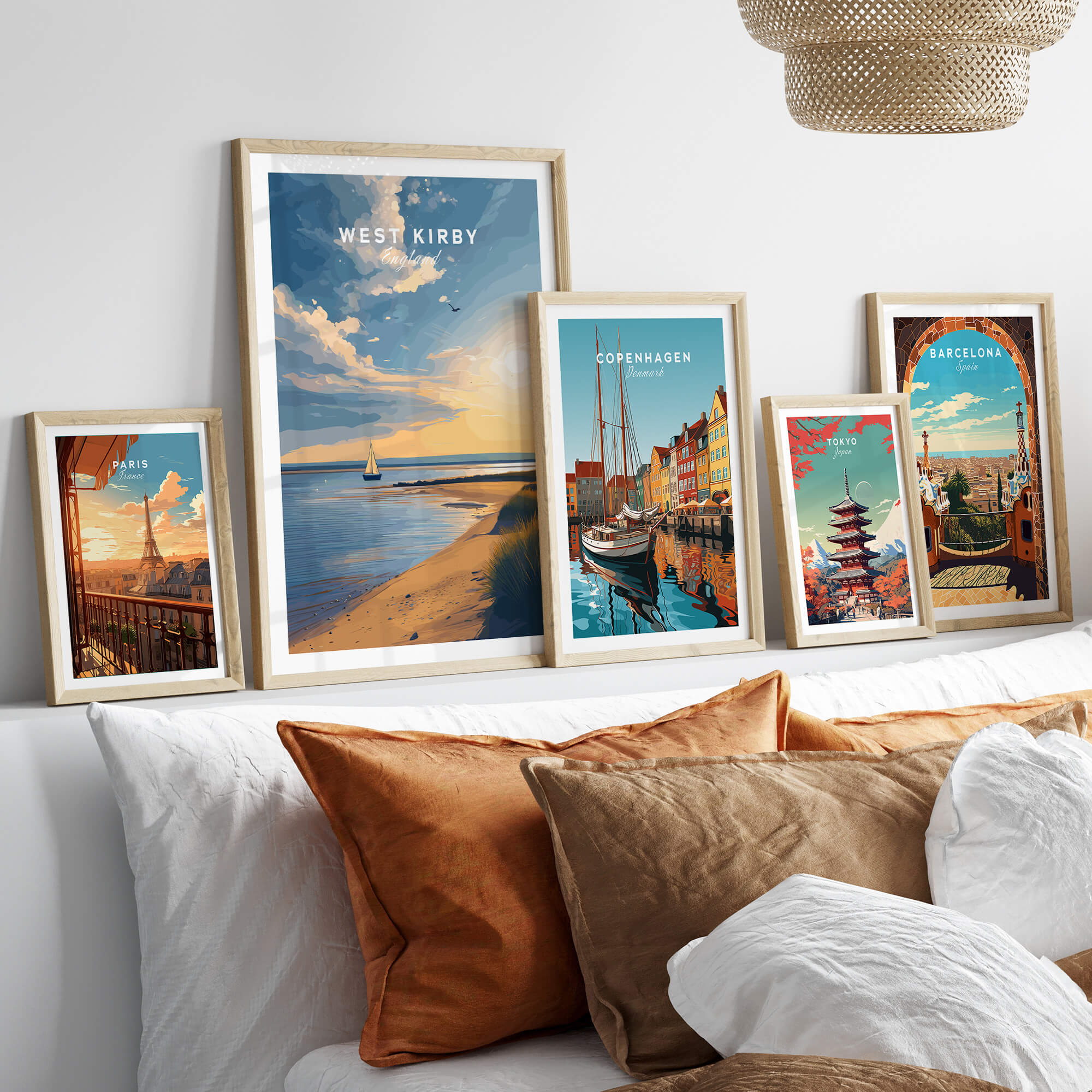 West Kirby England Travel Poster | Golden Sunset Beach Wall Art Print displayed among other travel posters on a cozy sofa.