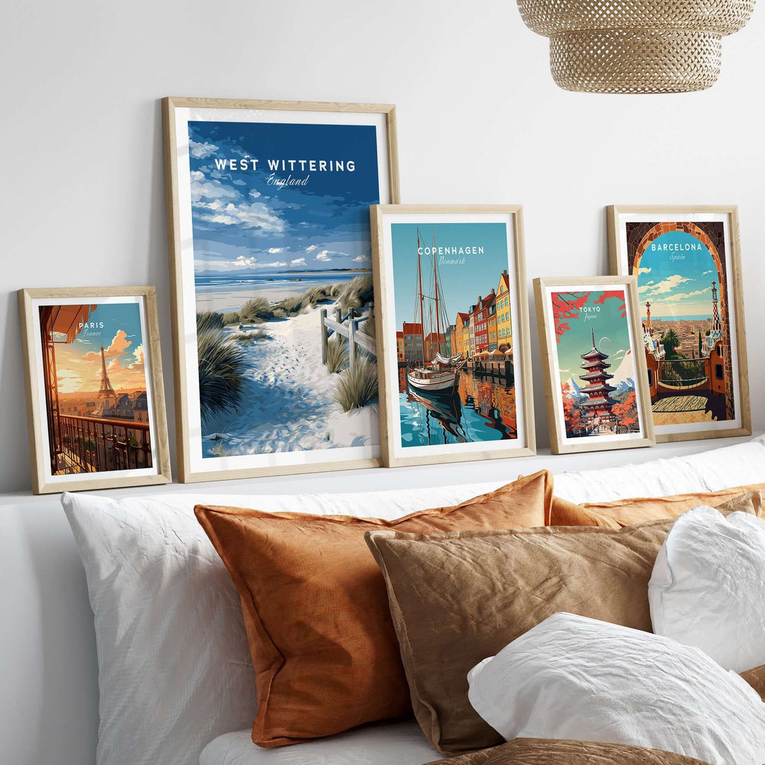 West Wittering Beach wall art and travel posters in stylish frames on a cozy bed with cushions.