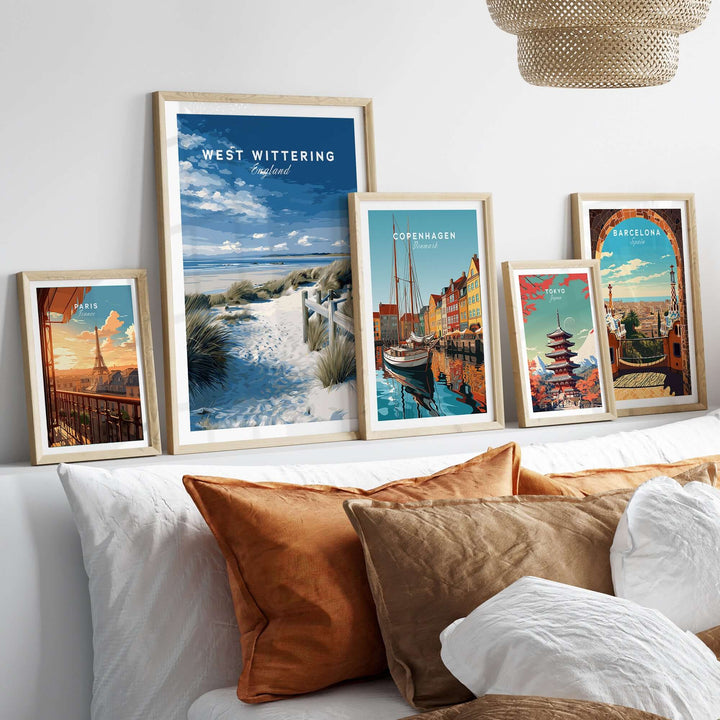 West Wittering Beach wall art and travel posters in stylish frames on a cozy bed with cushions.