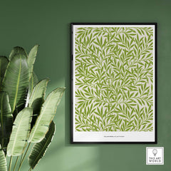 Exhibition Art Print William Morris Willow Pattern Green Botanical Wall Art displayed on green wall with plant.