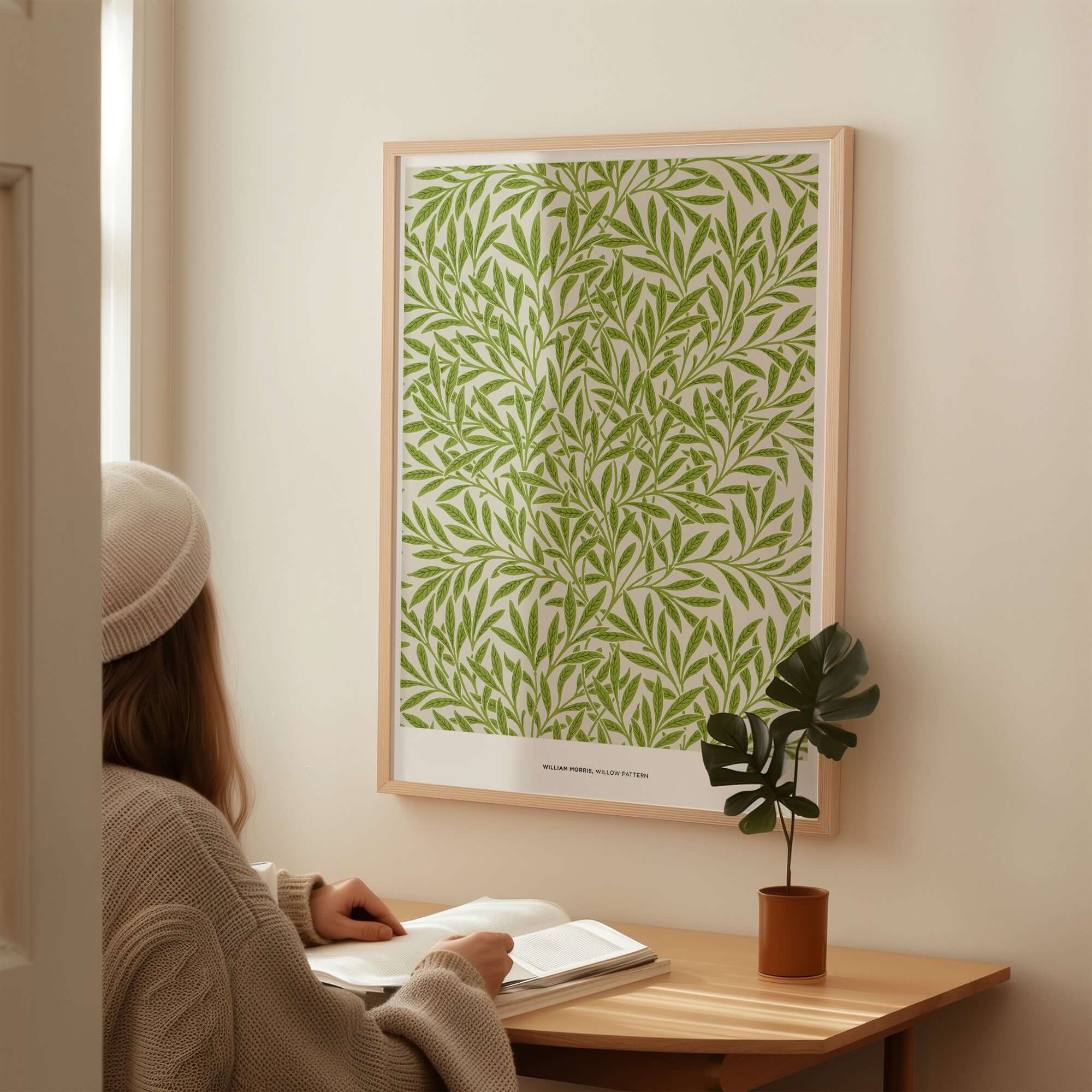 Exhibition Art Print William Morris Willow Pattern Green Botanical Wall Art displayed on a wall with a person reading.