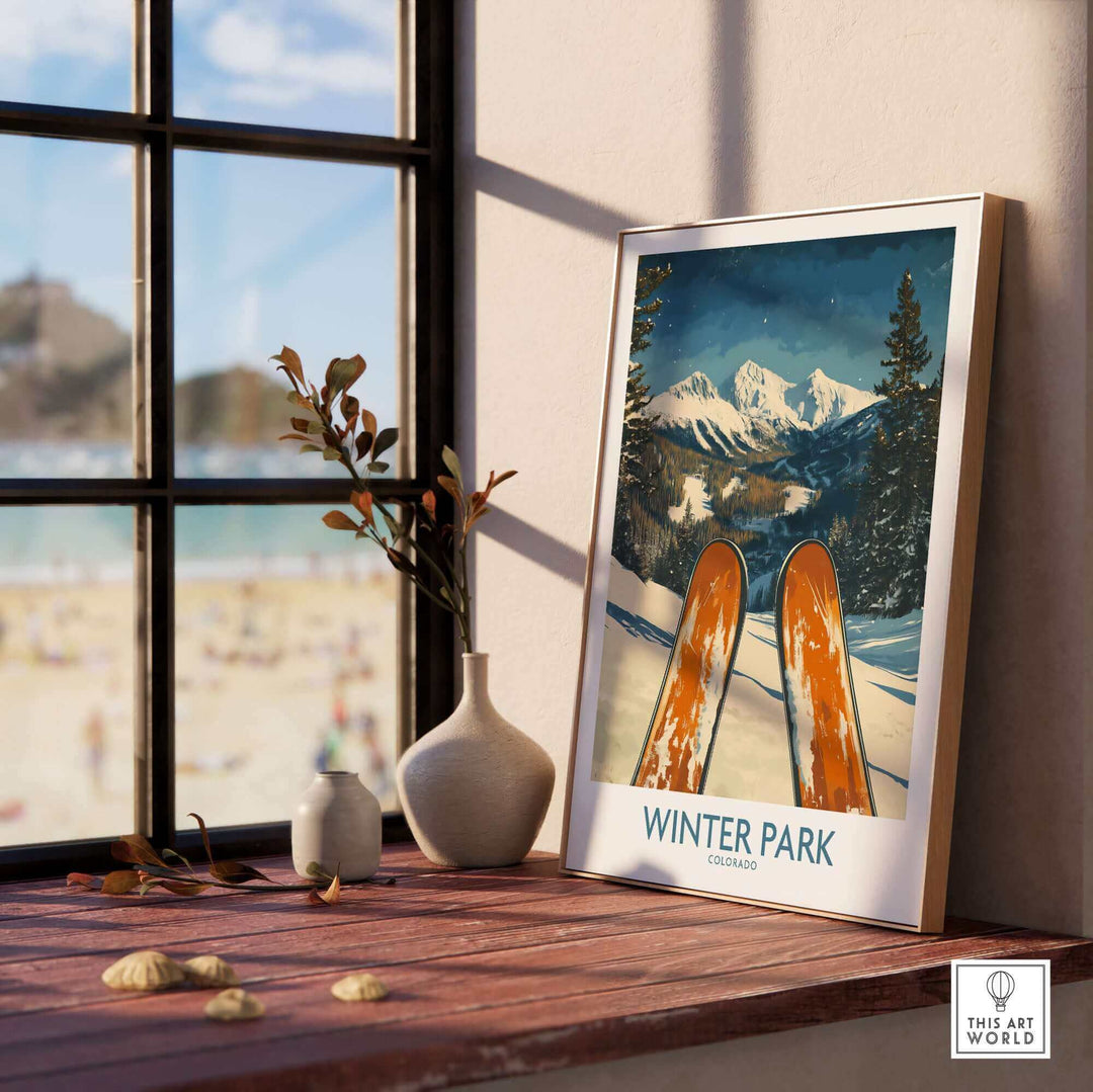 Winter Park Colorado Ski Poster Wall Art displayed on a windowsill with a snowy mountain scene and ski equipment.