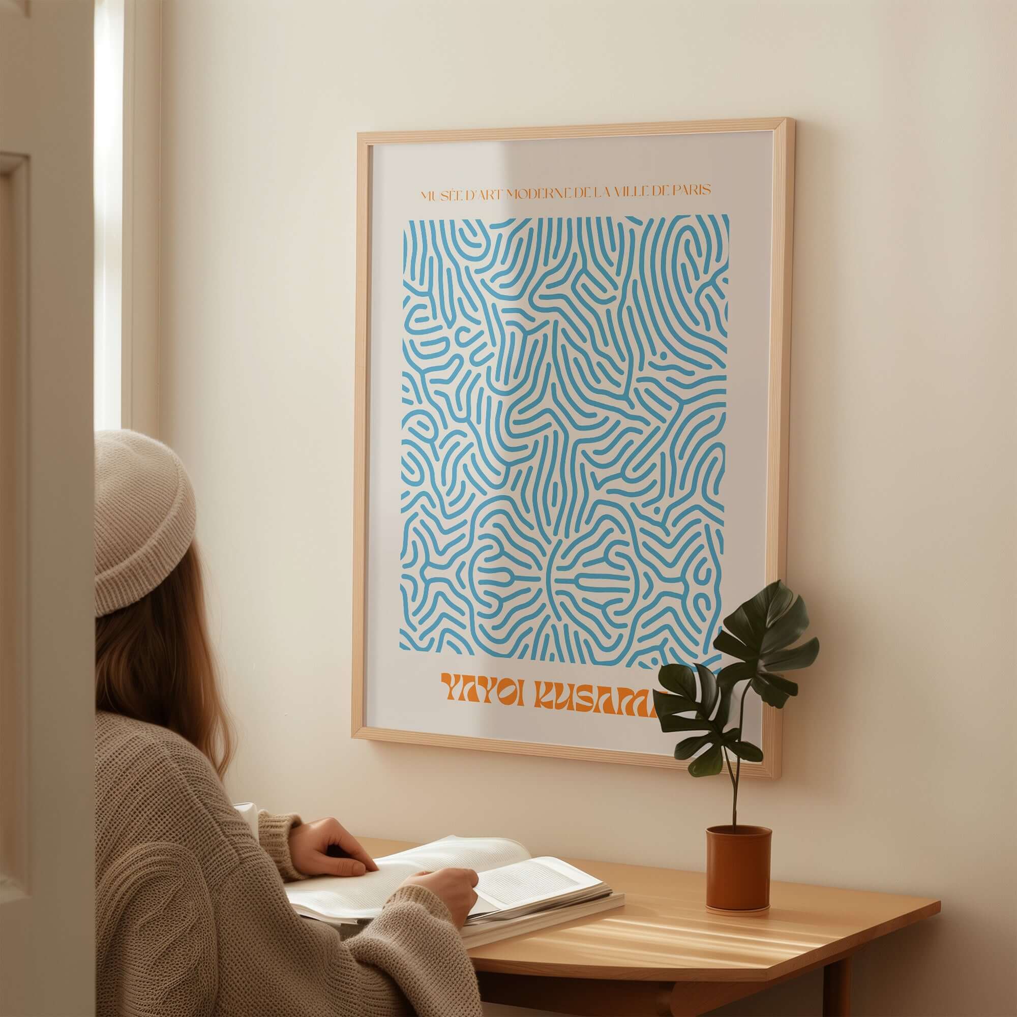 Yayoi Kusama Blue Infinity Net Pattern Abstract Art Print Paris Exhibition Poster displayed on a wall in a cozy interior setting.