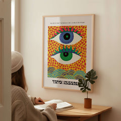 Yayoi Kusama Colorful Eyes Abstract Pattern Contemporary Art Print Paris Poster displayed on a wall with a person admiring it.