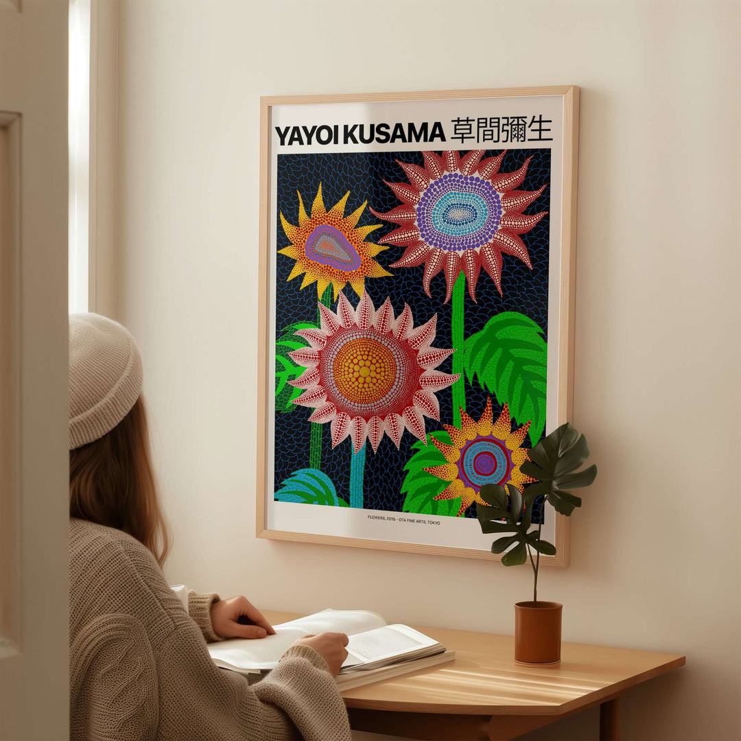 Yayoi Kusama colorful flowers art print poster on a wall, person admiring contemporary polka dot wall art in a cozy setting.