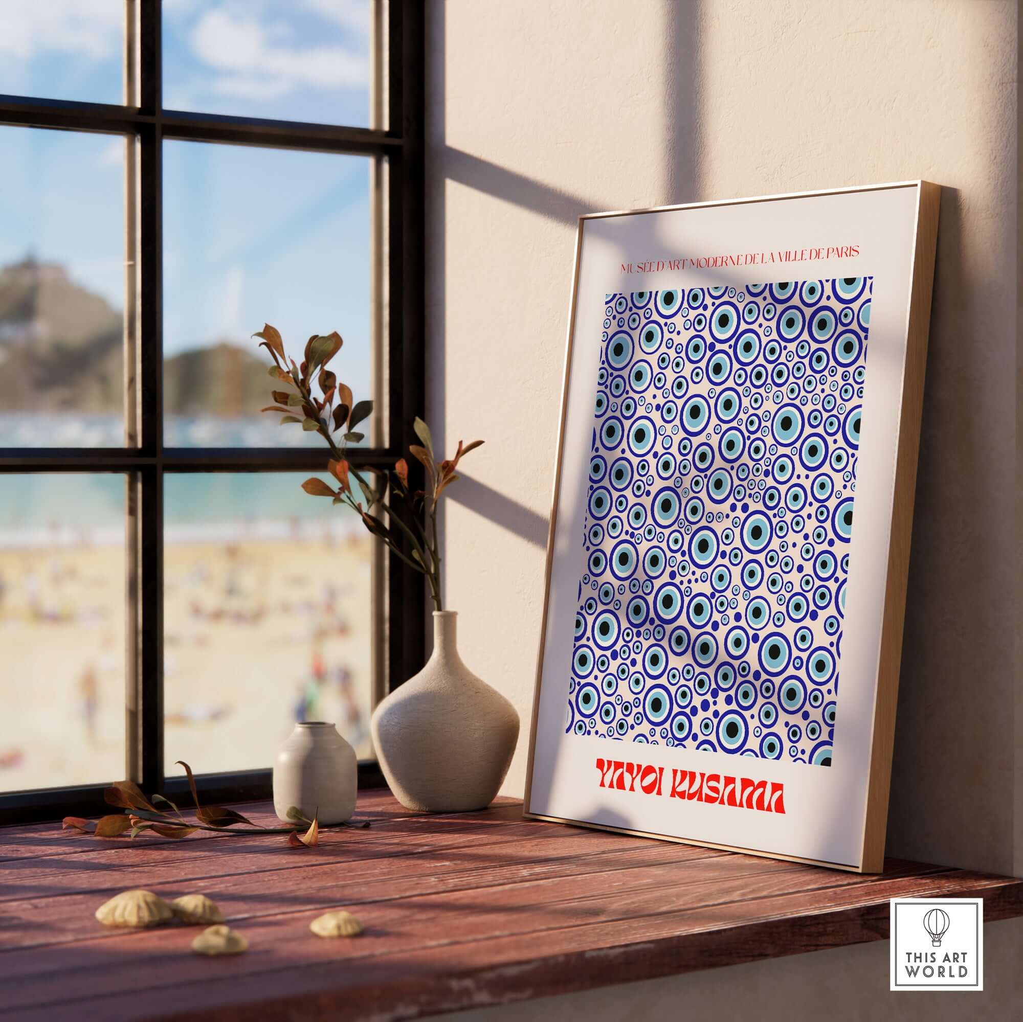 Yayoi Kusama Evil Eye Pattern Blue Contemporary Art Print Poster Paris Wall Decor displayed on a windowsill with beach view.