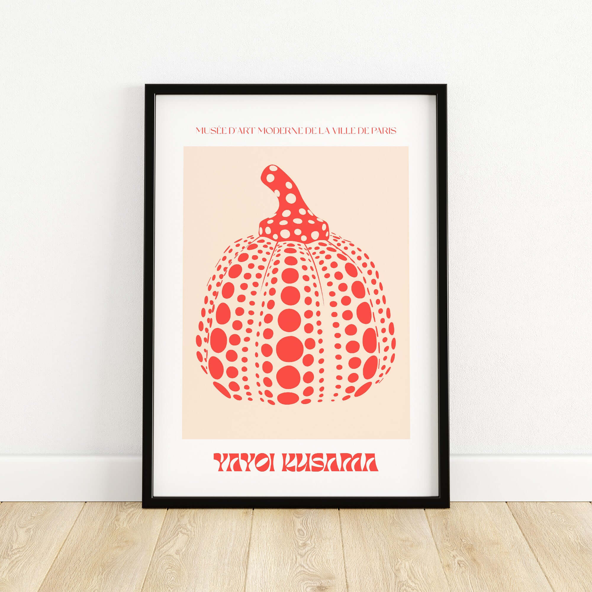 Yayoi Kusama Red Pumpkin Polka Dot Pop Art Print Poster Paris Exhibition Wall Art in a black frame on a wooden floor.