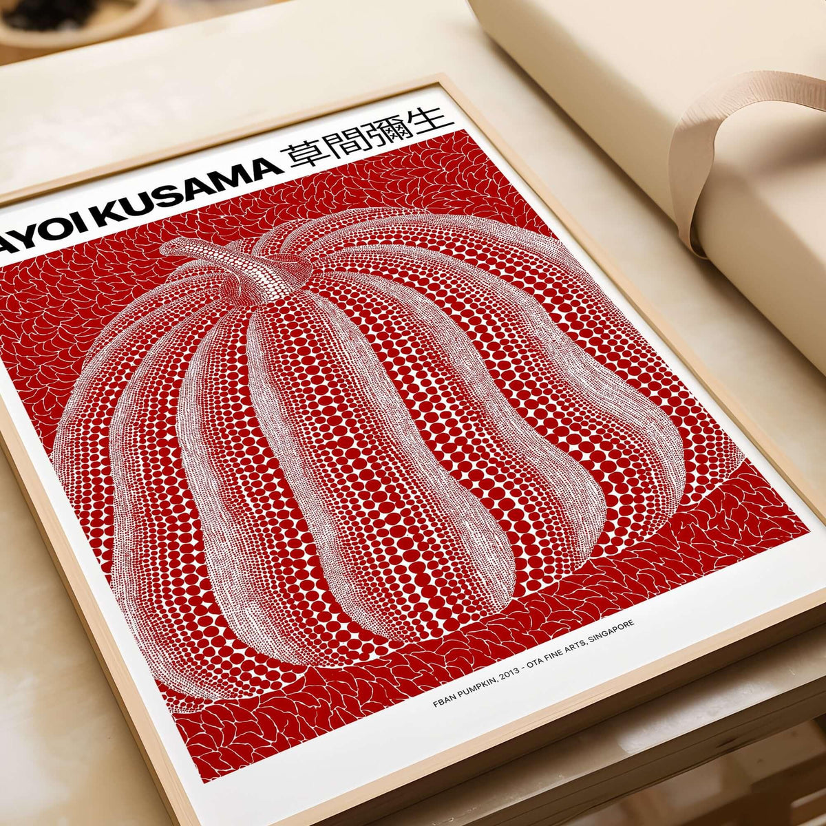 Red polka dot pumpkin art print poster in frame, inspired by Yayoi Kusama, on table